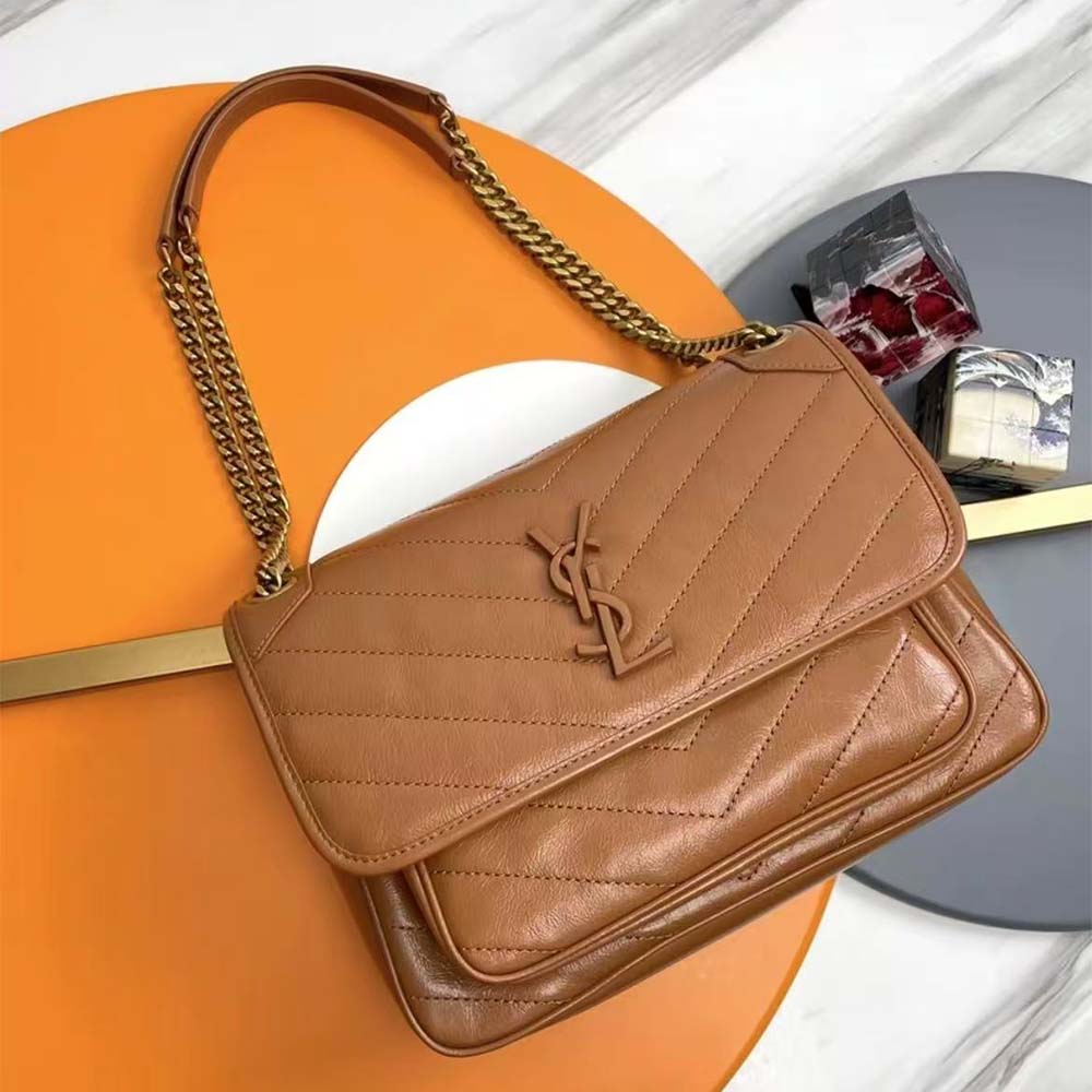 Close-up of gold-toned YSL logo on Niki Small vintage leather bag