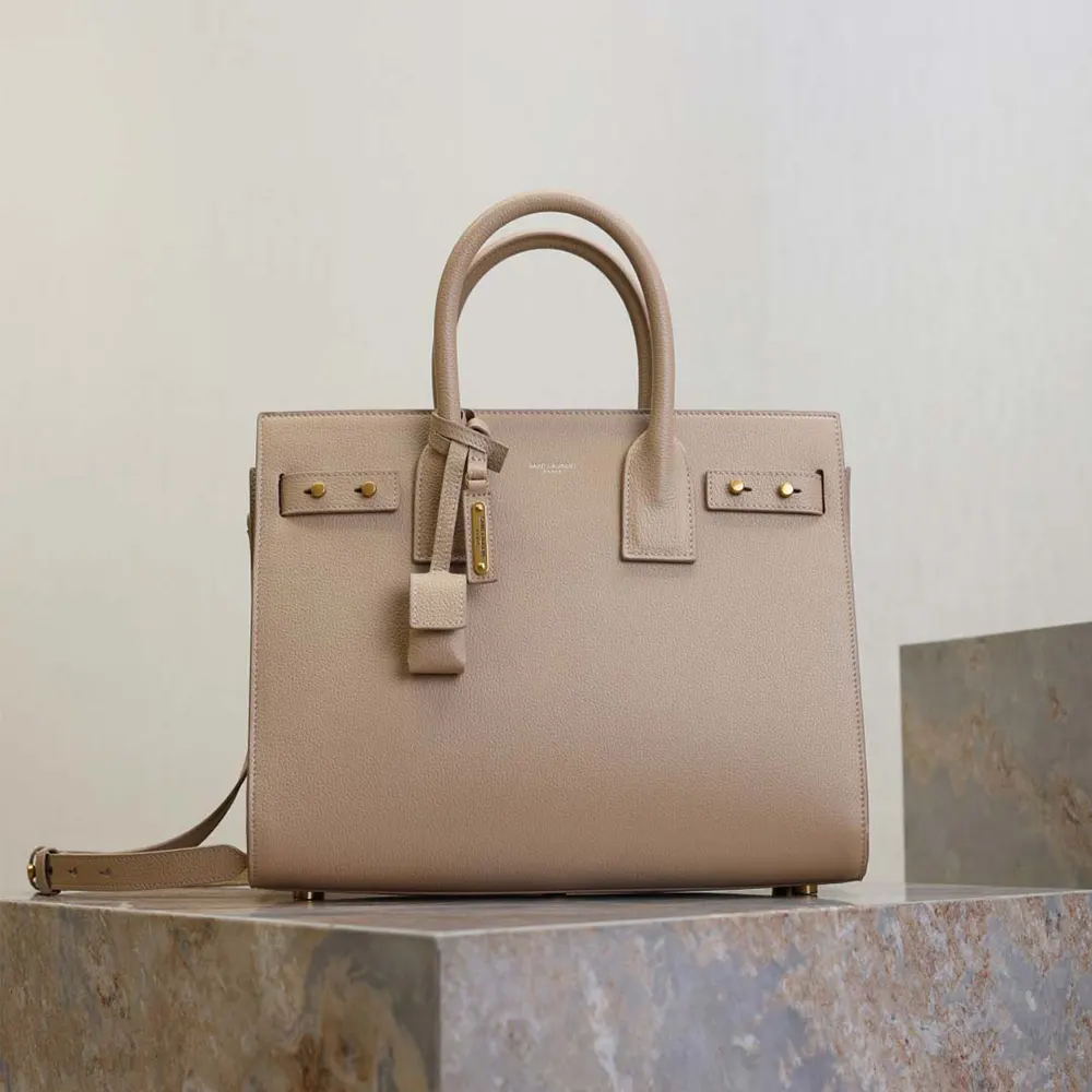 Close-up of gold-tone YSL logo hardware on Saint Laurent YSL Small Sac De Jour bag