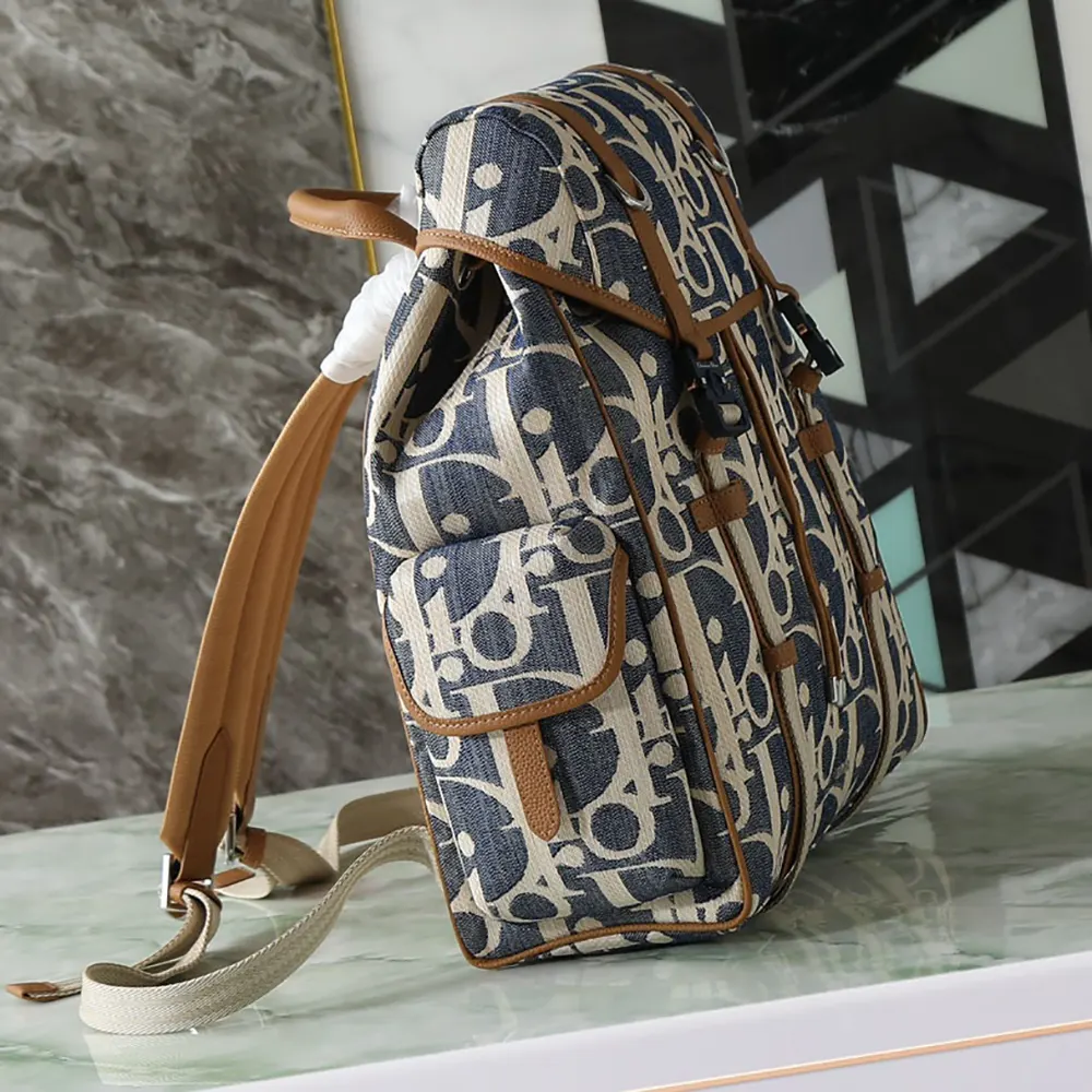 Side angle showing silver hardware and adjustable straps on Dior backpack