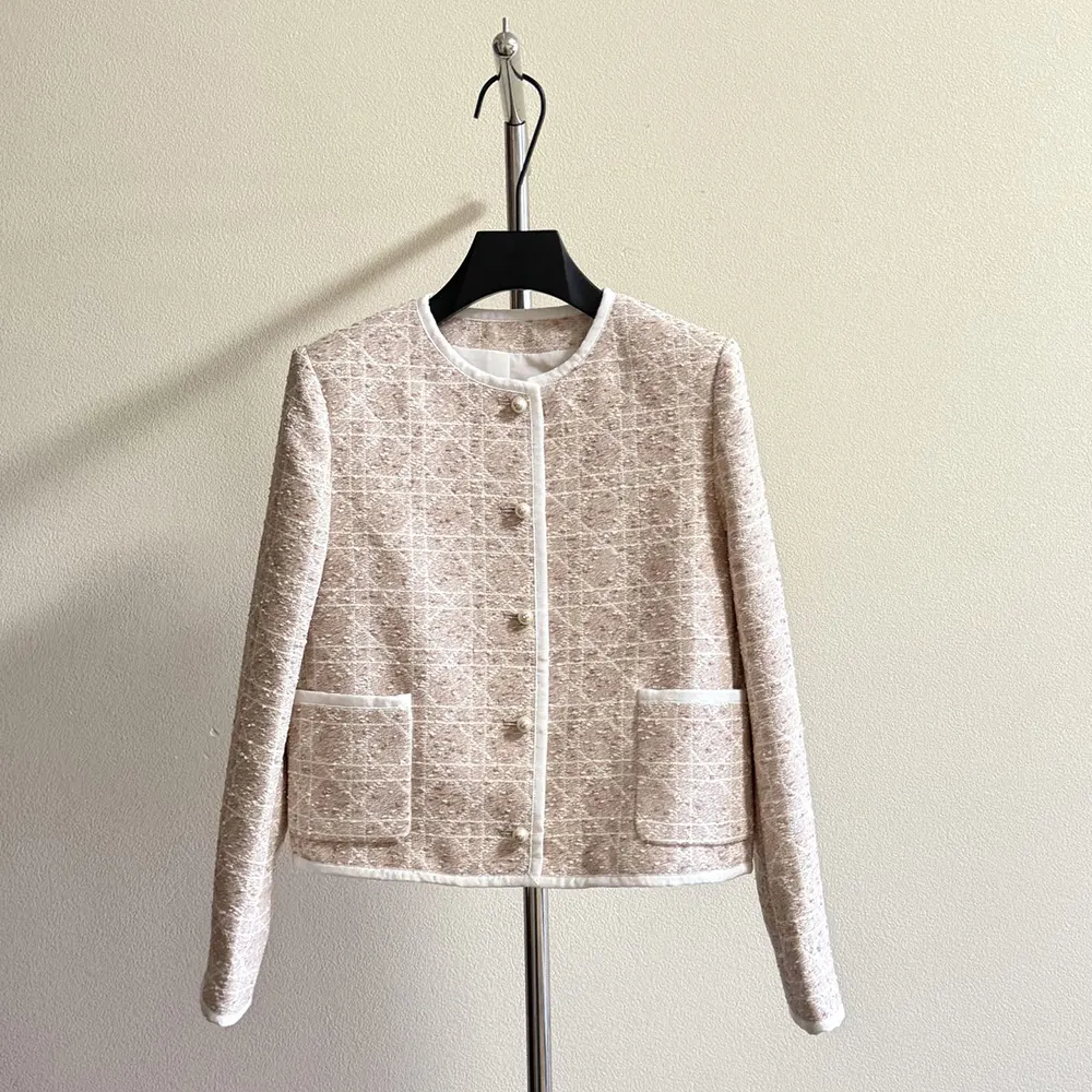 Close-up of gold-tone buttons and macrocannage pattern on cropped jacket