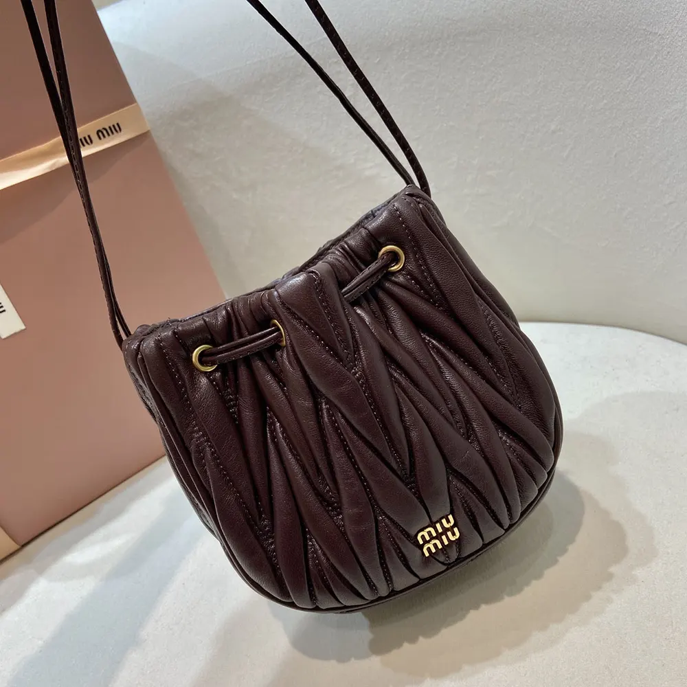 Close-up of matelassé stitching and silver hardware on Miu Miu pouch