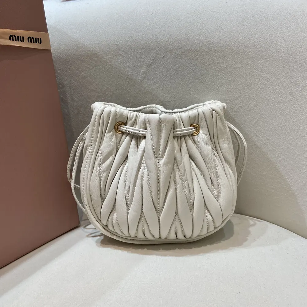 Side angle highlighting compact silhouette of Miu Miu Women Matelassé Nappa Leather Pouch-White
