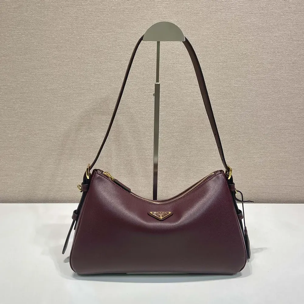 Close-up of gold-tone hardware on Prada Women Aimée Medium Shoulder Bag