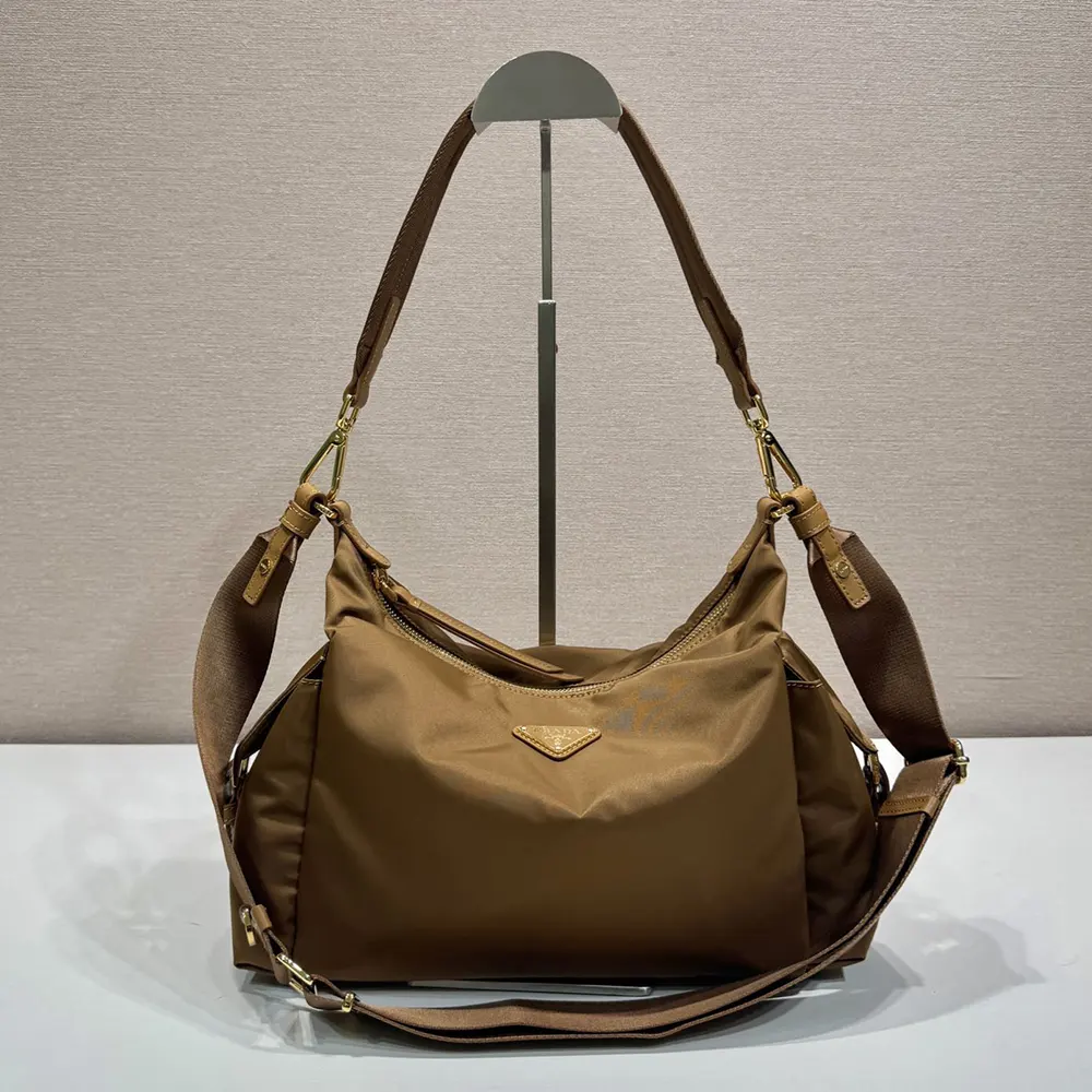 Close-up of silver Prada logo on brown Re-Nylon shoulder bag flap