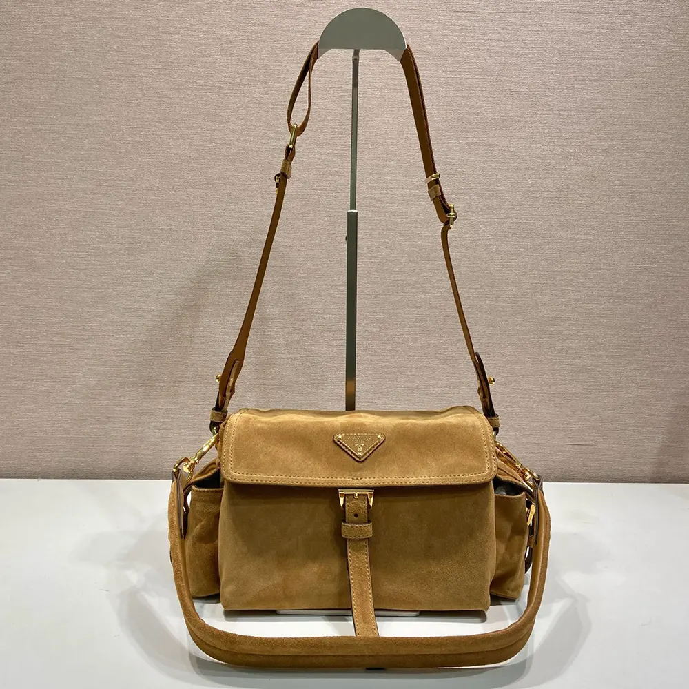 Close-up detail of gold hardware on Prada Women Explore Medium Suede Shoulder Bag
