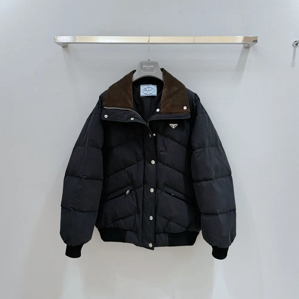 Close-up of signature Prada hardware on black poplin down jacket