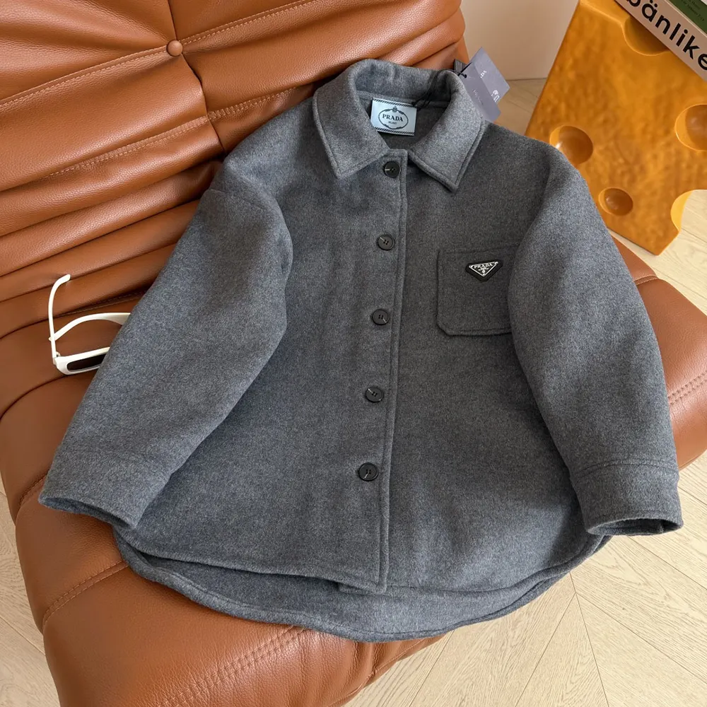 Close-up of Prada branded buttons on gray double cashwool caban jacket