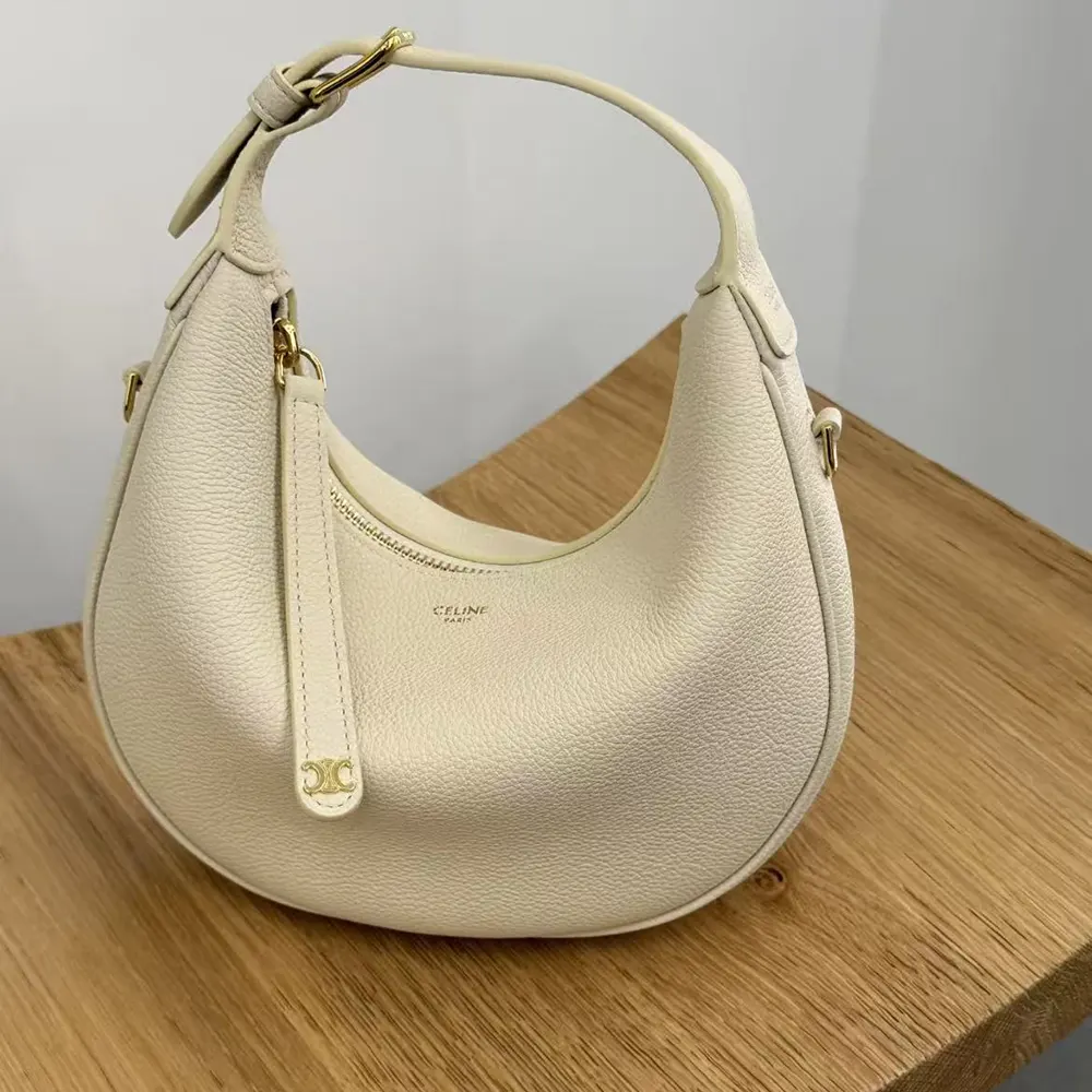 Close-up of beige grained calfskin texture and gold hardware