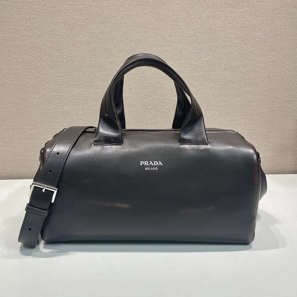 Close-up of gold hardware and nappa leather texture on Prada duffle bag