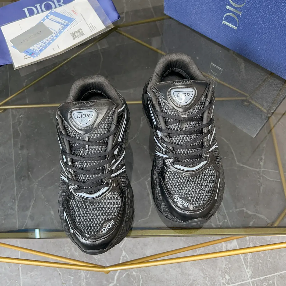 Close-up detail of Dior logo hardware on black B35 NXXT sneaker tongue