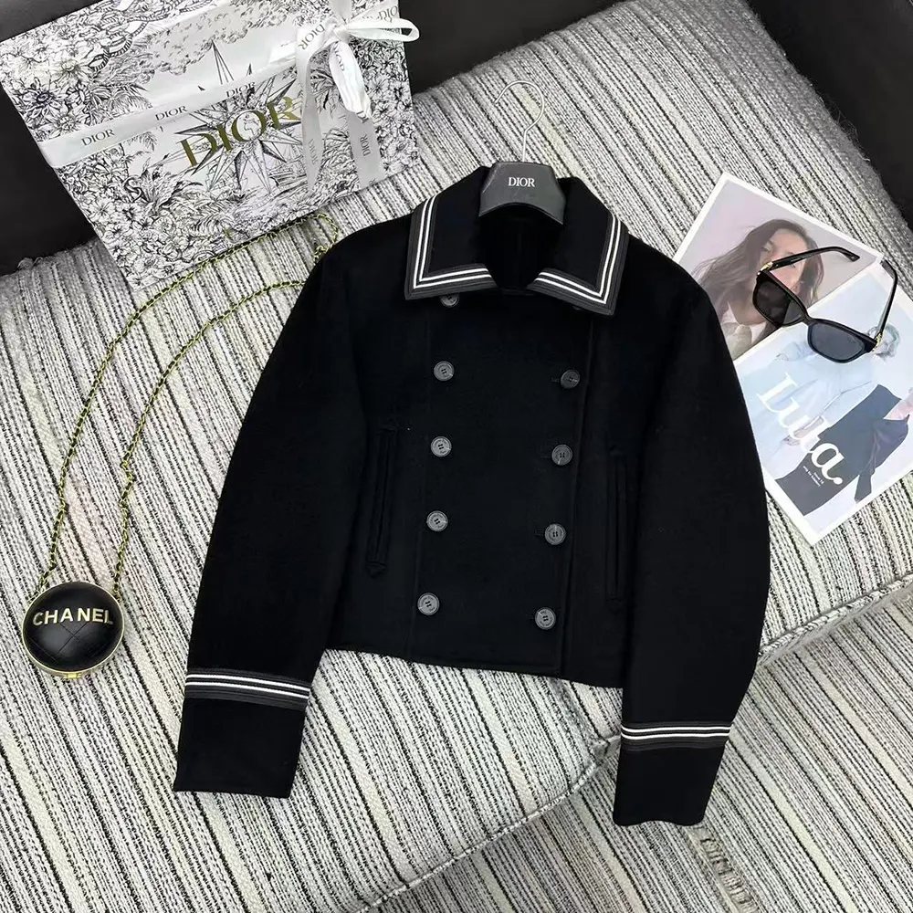 Close-up of signature Dior engraved buttons on the black peacoat