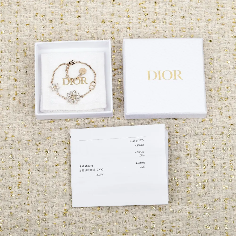 Close-up of gold finish and CD logo on Dior Women Petit CD Lucky Baroque Earrings