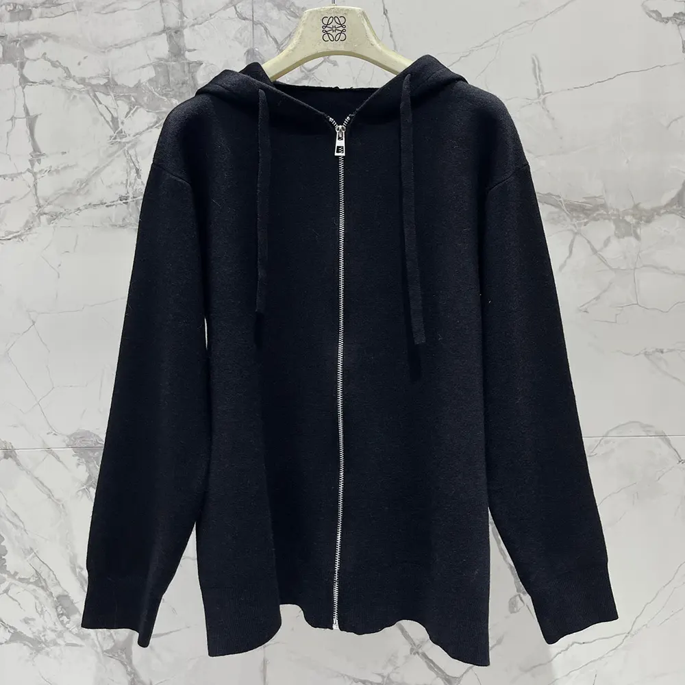 Close-up of Anagram embossed hardware on black wool hoodie