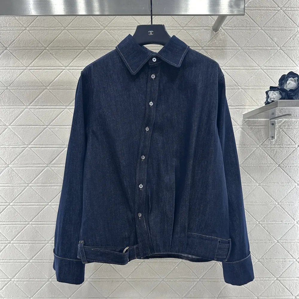 Close-up of Loewe embossed buttons on draped denim shirt