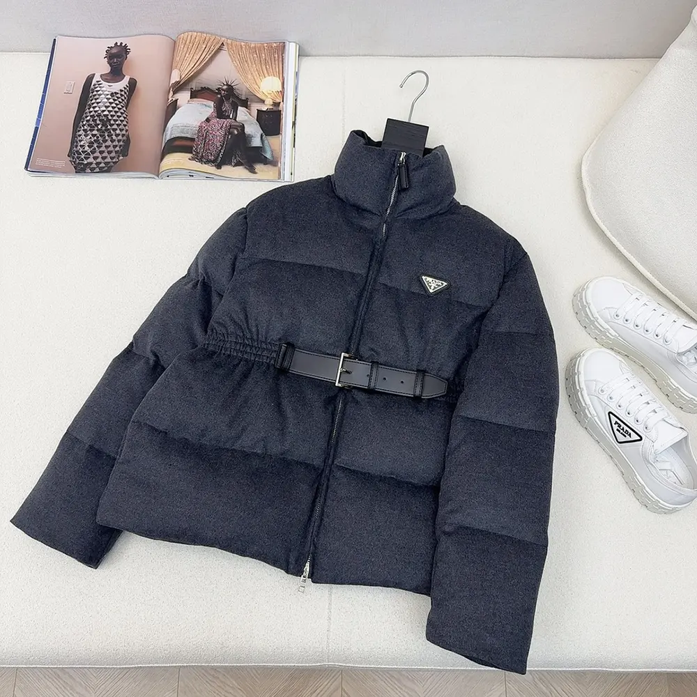 Close-up of Prada branded metal hardware on grey down jacket