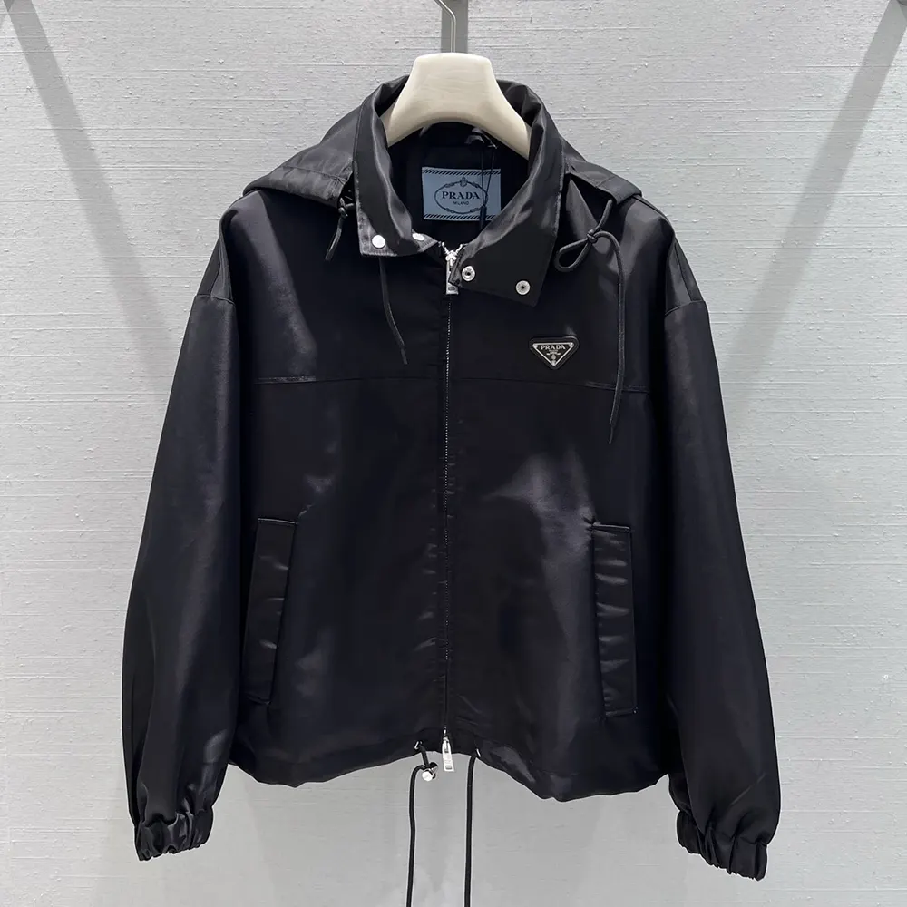 Close-up of Prada logo plaque on black Re-Nylon blouson jacket
