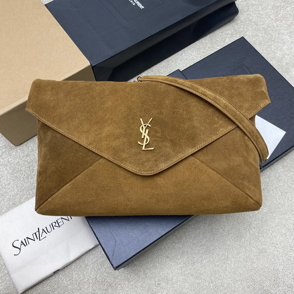 Close-up of gold YSL logo hardware on suede pouch
