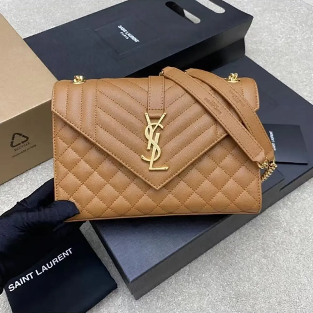 Close-up of gold YSL hardware on brown lambskin envelope bag