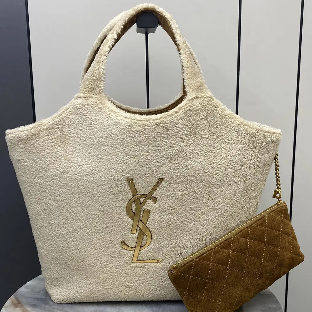 Close-up of gold YSL logo hardware on Icare Shearling-White bag