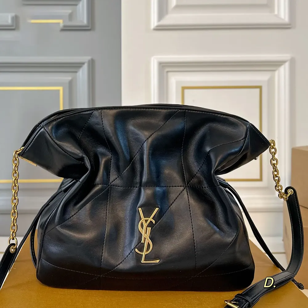 Close-up of gold YSL logo hardware on Jamie Shopping Small bag