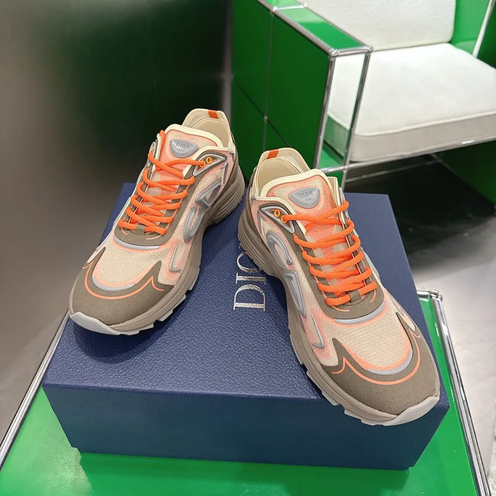 Angled shot showing silver Dior hardware and bright orange laces