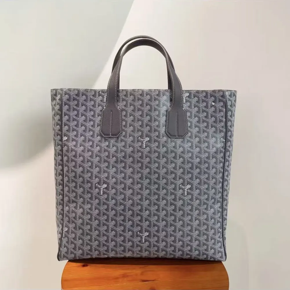 Side angle showing zip-top closure and leather handles of Voltaire Tote bag