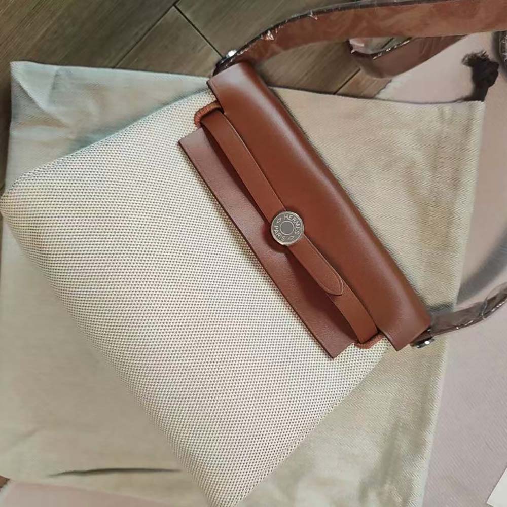 Side angle showing gold hardware on Hermes Women Herbag Zip 20 Bag-Brown
