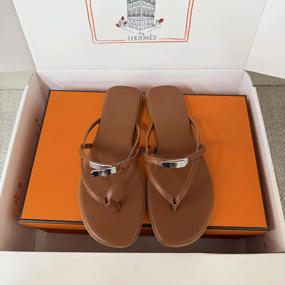 Close-up of signature Hermes H hardware on brown calfskin sandal