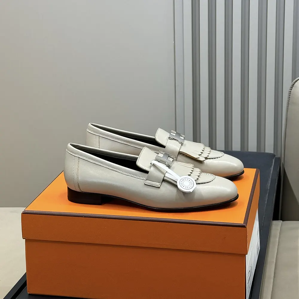 Close-up of signature Hermes hardware on gray goatskin loafer