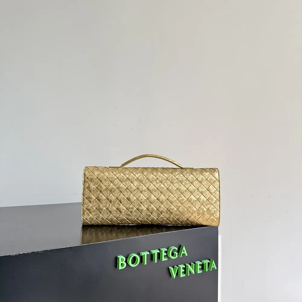 Side angle of Bottega Veneta Women Andiamo Clutch-Gold with shoulder strap attached