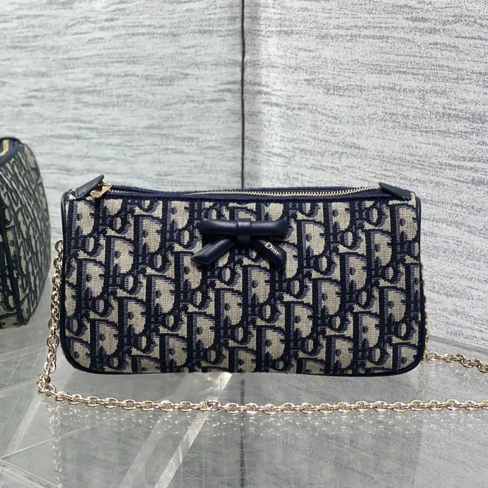 Close-up of bow detail and silver hardware on Dior Women Oblique Bow Pouch