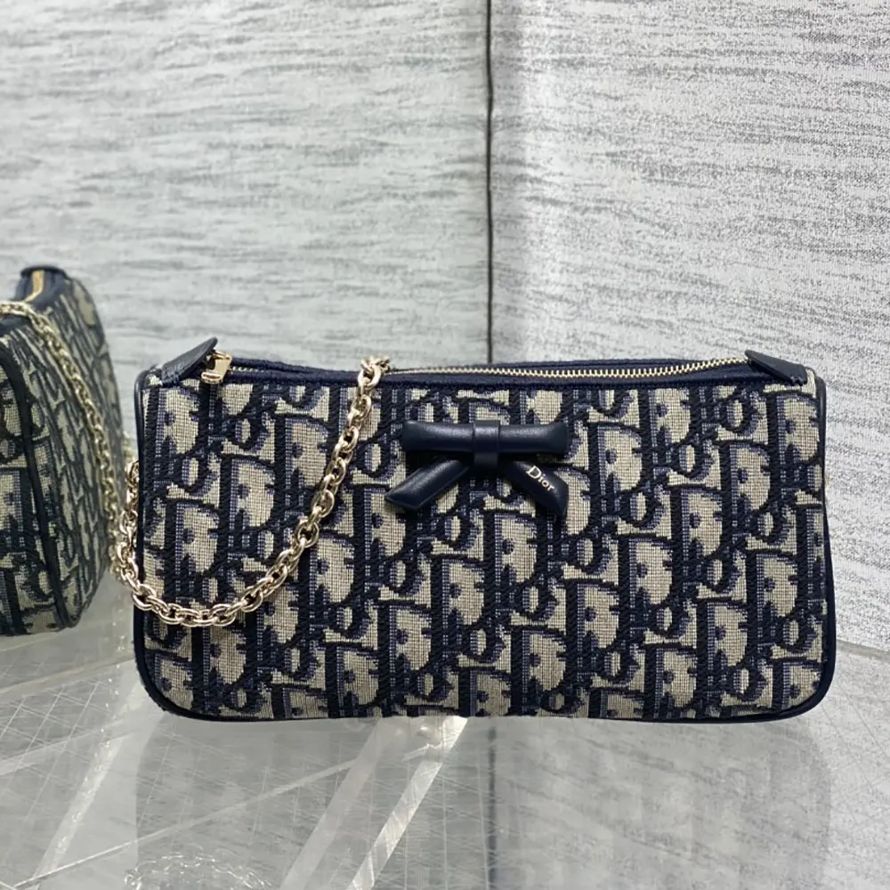 Side angle showing chain strap and zipper of Dior Women Oblique Bow Pouch