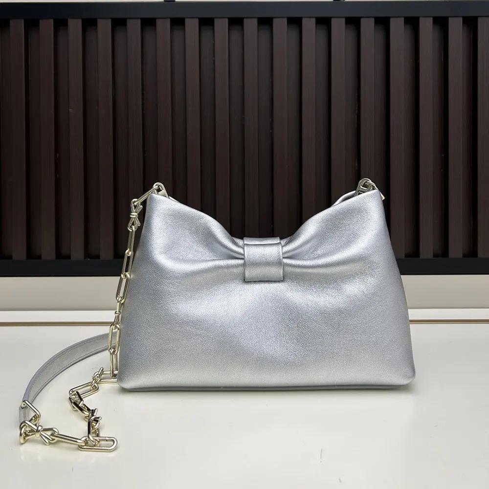 Side angle showing laminated lambskin texture on Dior Women Or Small Dior Bow Bag