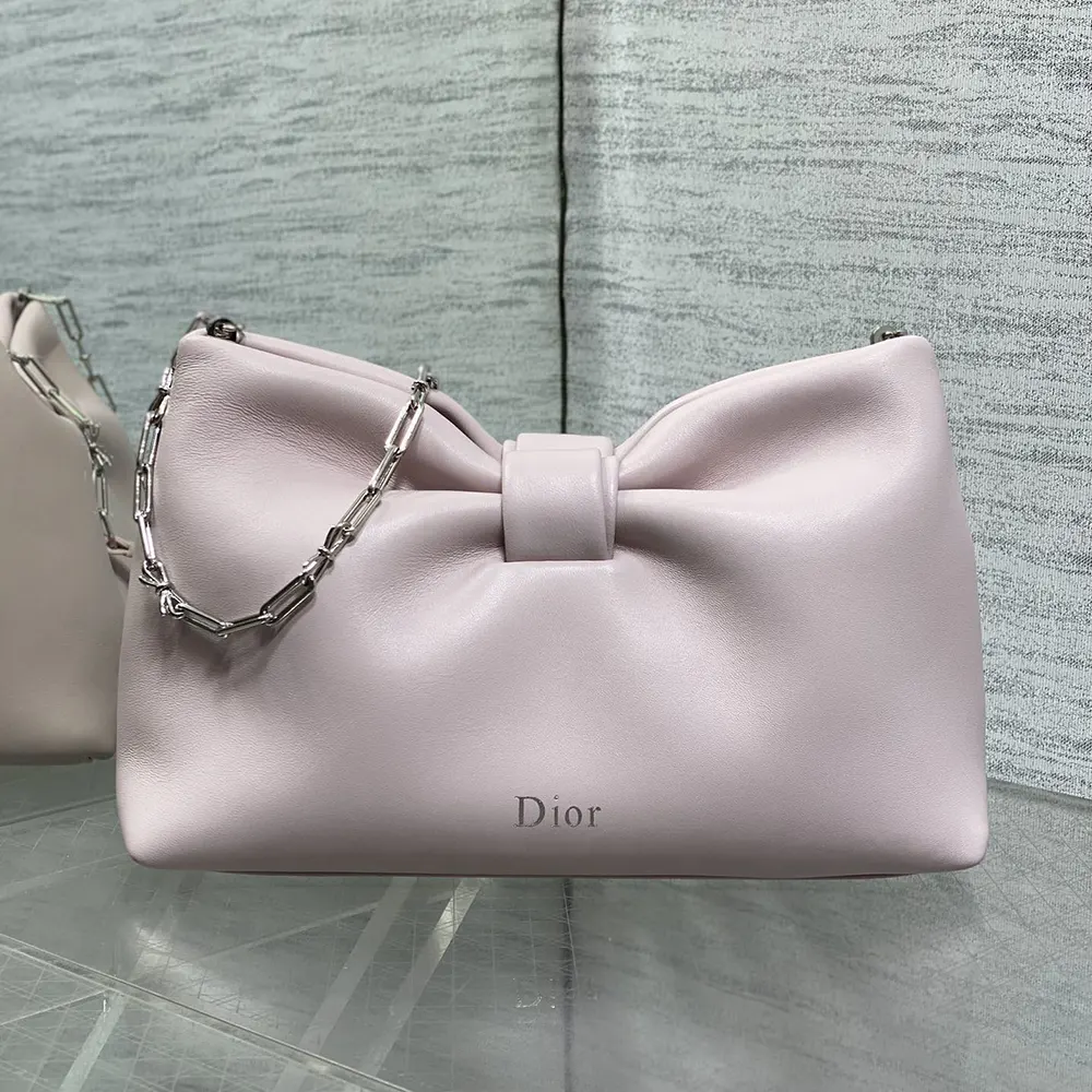 Close-up of silver Dior bow detail on pink lambskin bag