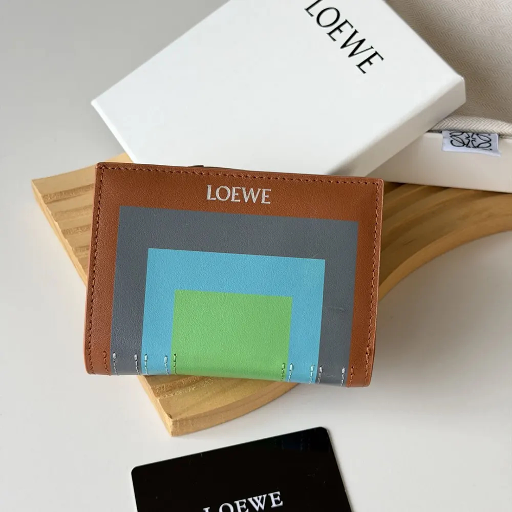 Close-up of embossed Loewe logo on compact wallet in brown leather