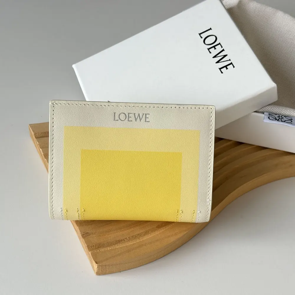 Close-up of silver Loewe logo on compact white wallet