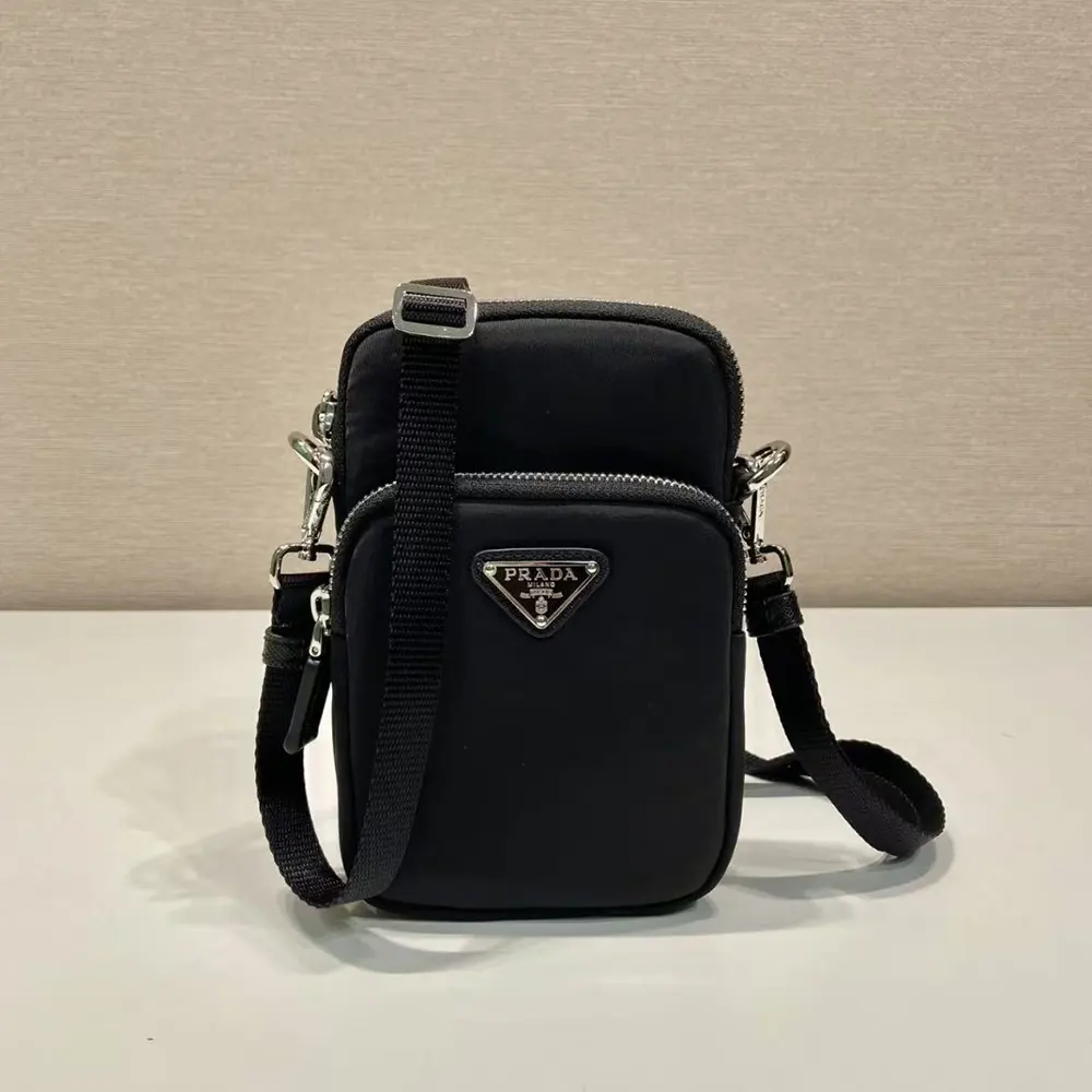 Close-up detail of Prada silver-tone logo hardware on nylon case