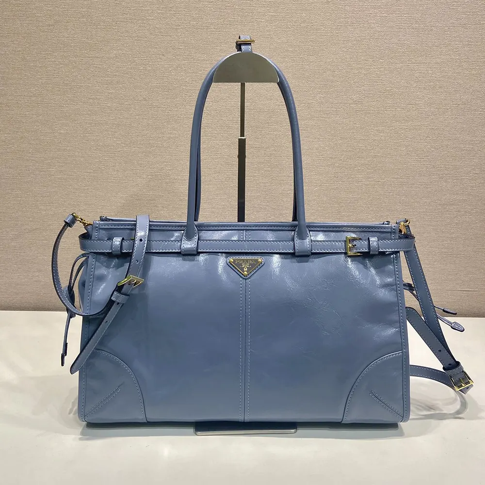 Close-up of silver Prada logo on large leather handbag