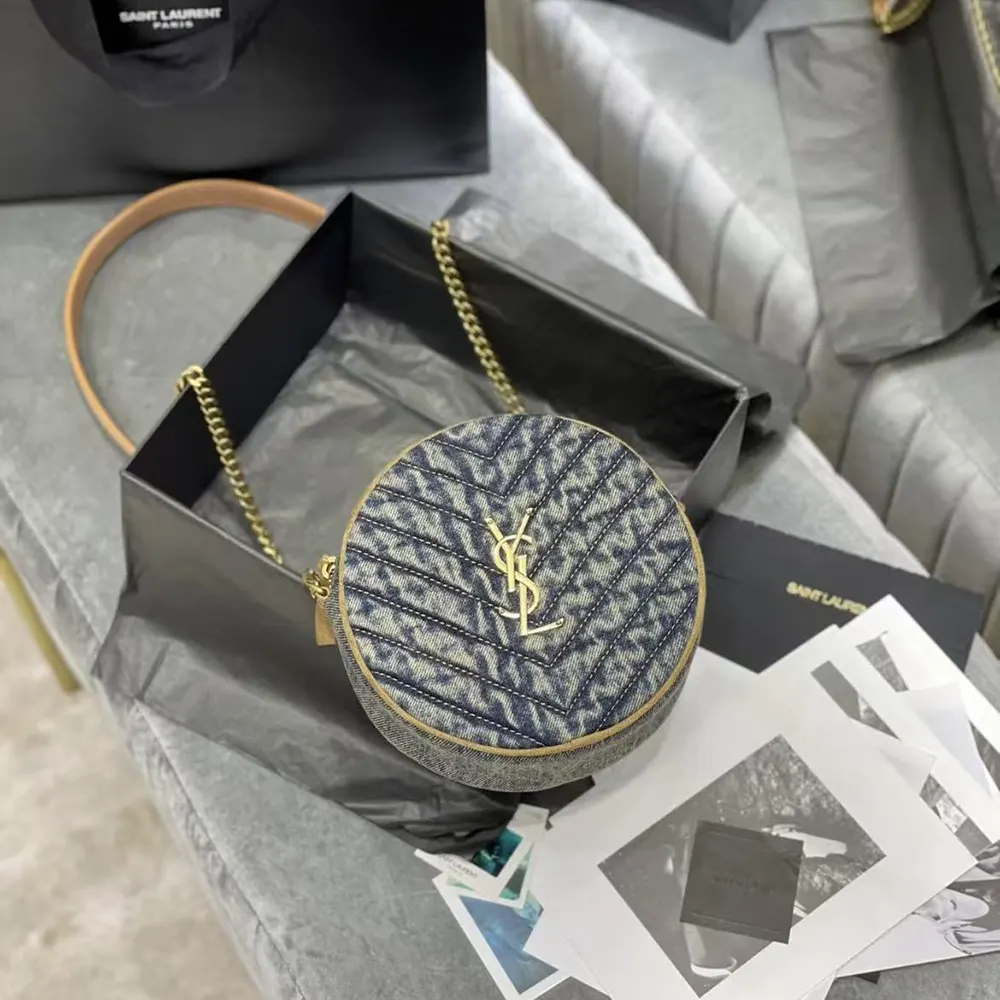 Close-up of gold YSL logo plaque on navy crossbody bag