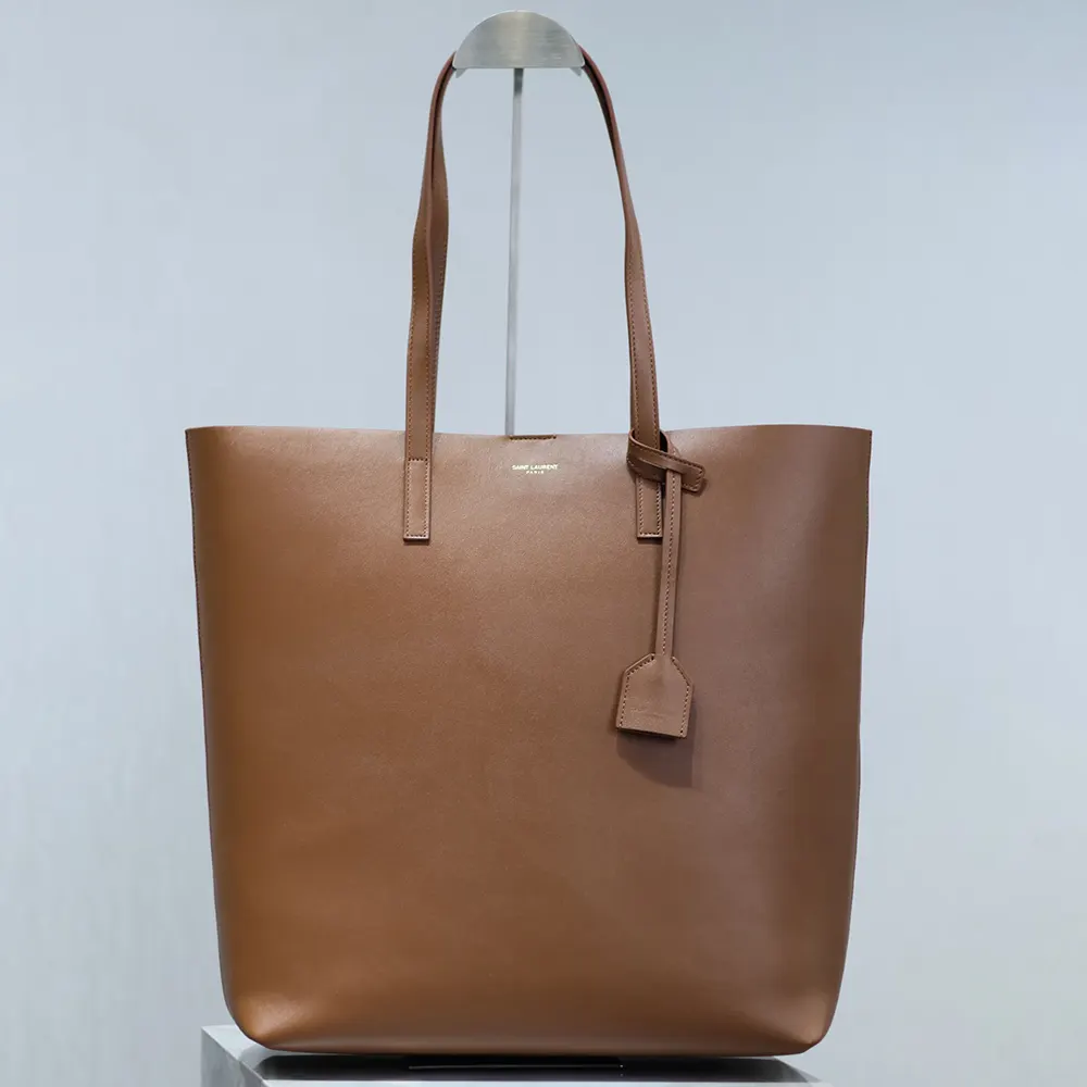 Close-up of gold YSL logo hardware on Leather-Brown Saint Laurent bag