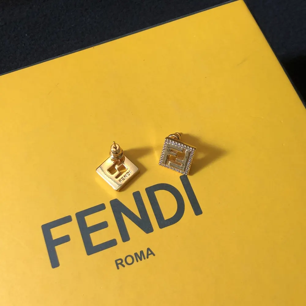Detailed shot of iconic Forever Fendi logo on gold-colored earrings