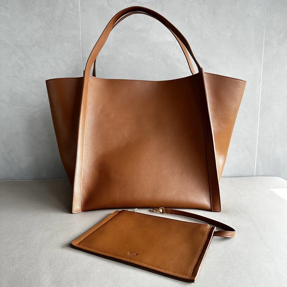 Side angle showing silhouette and flap closure of Celine brown cube bag