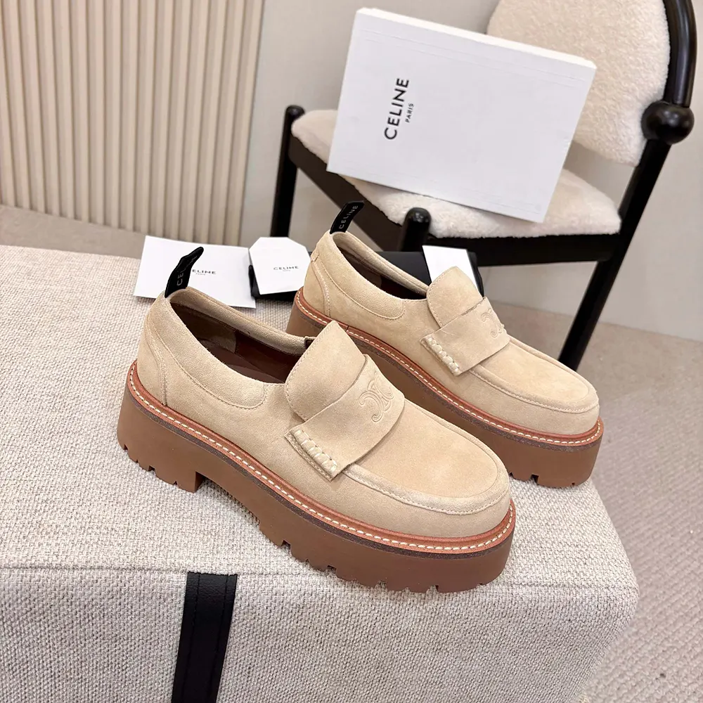 Close-up of gold Triomphe hardware on beige suede Celine loafers
