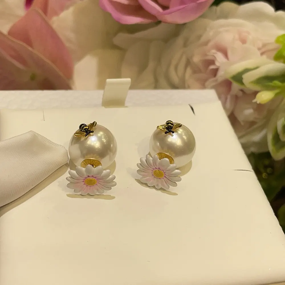 Side angle highlighting gold-finish metal and multicolor lacquer on Dior Tribales Earrings