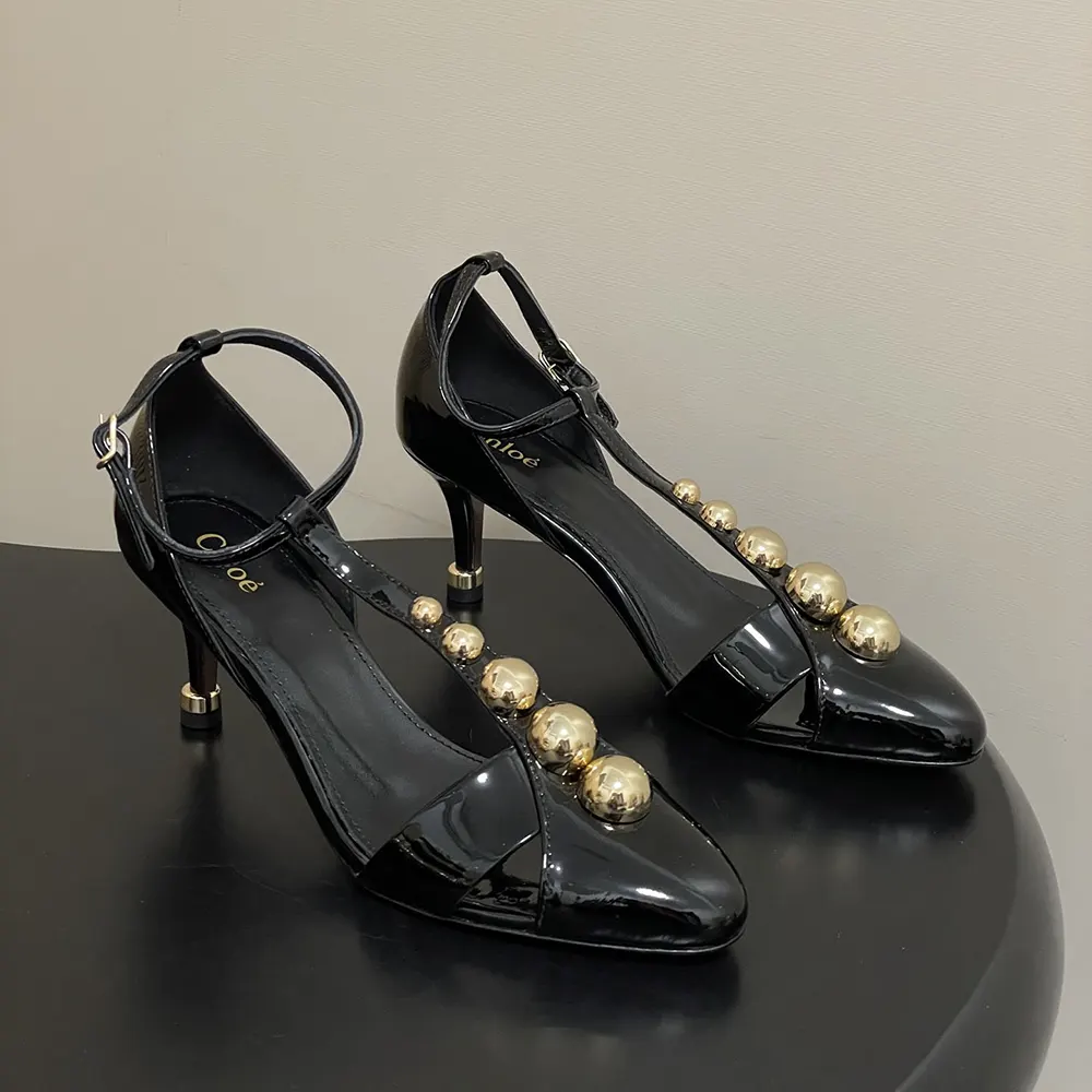Close-up of ankle strap with gold buckle on Chloe Women Cleia Heeled Sandal-Black
