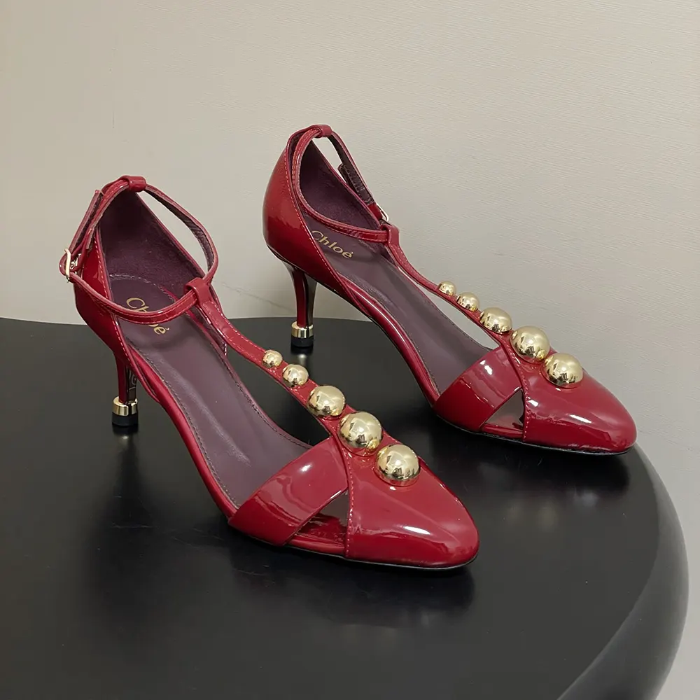 Close-up of red leather and gold knot detail on Chloe Women Cleia Heeled Sandal-Red