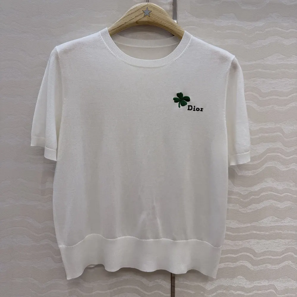 Close-up of green and black Dior Clover signature detail on sweater