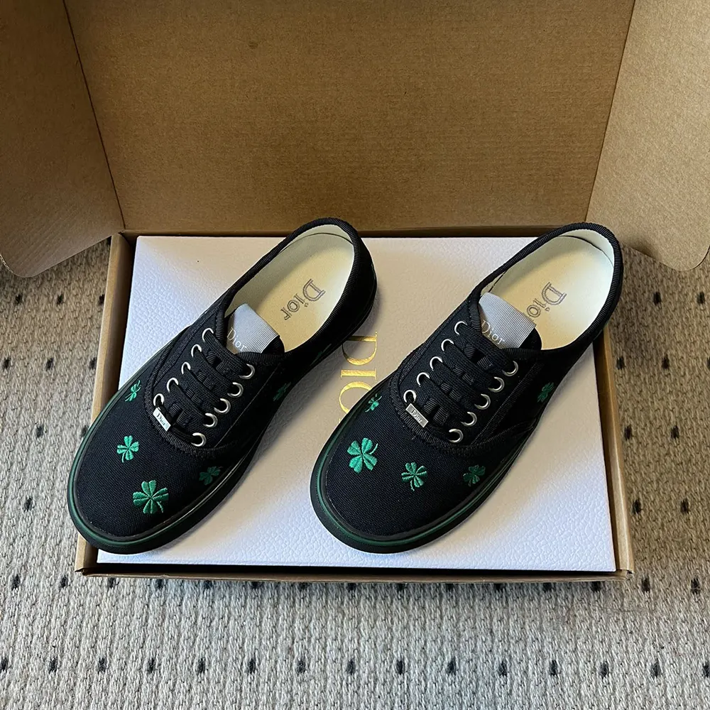 Close-up of bright green Dior clover embroidery on black sneaker
