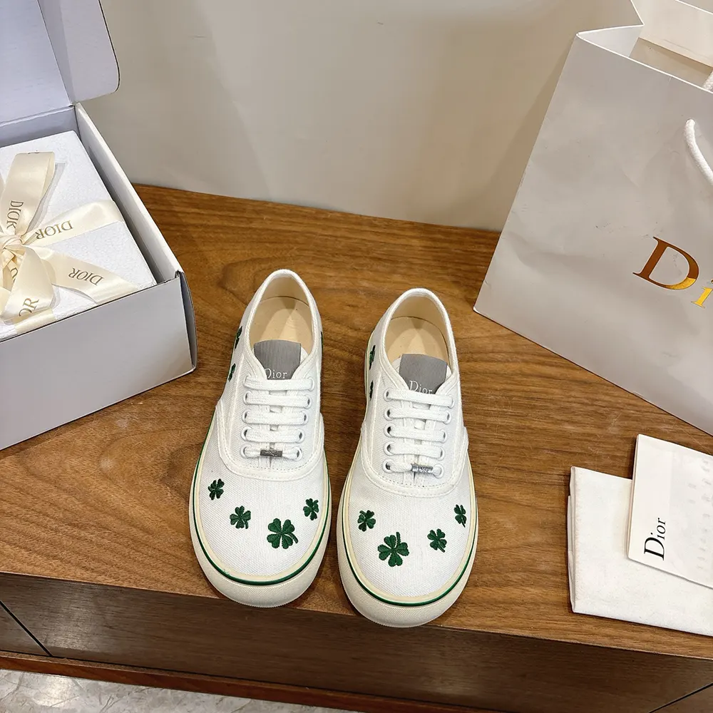Close-up of bright green Dior clover embroidery on white cotton sneaker