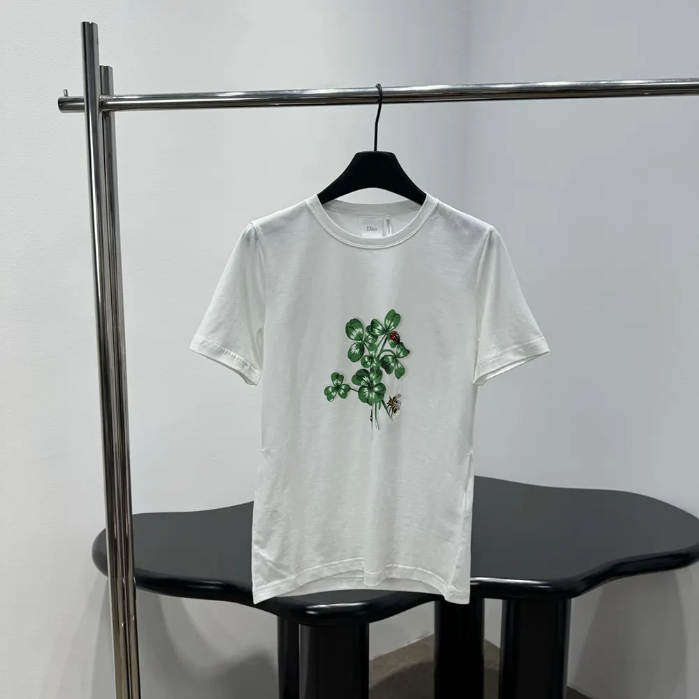 Close-up of green Dior clover motif on white cotton jersey t-shirt